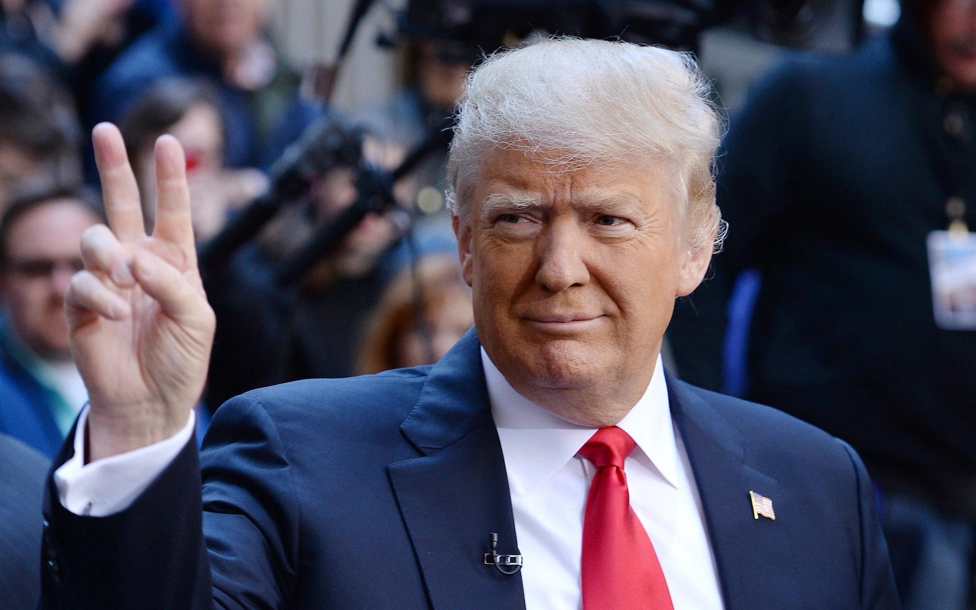 PRESIDENT DONALD TRUMP HOLDING UP THE PEACE SIGN
