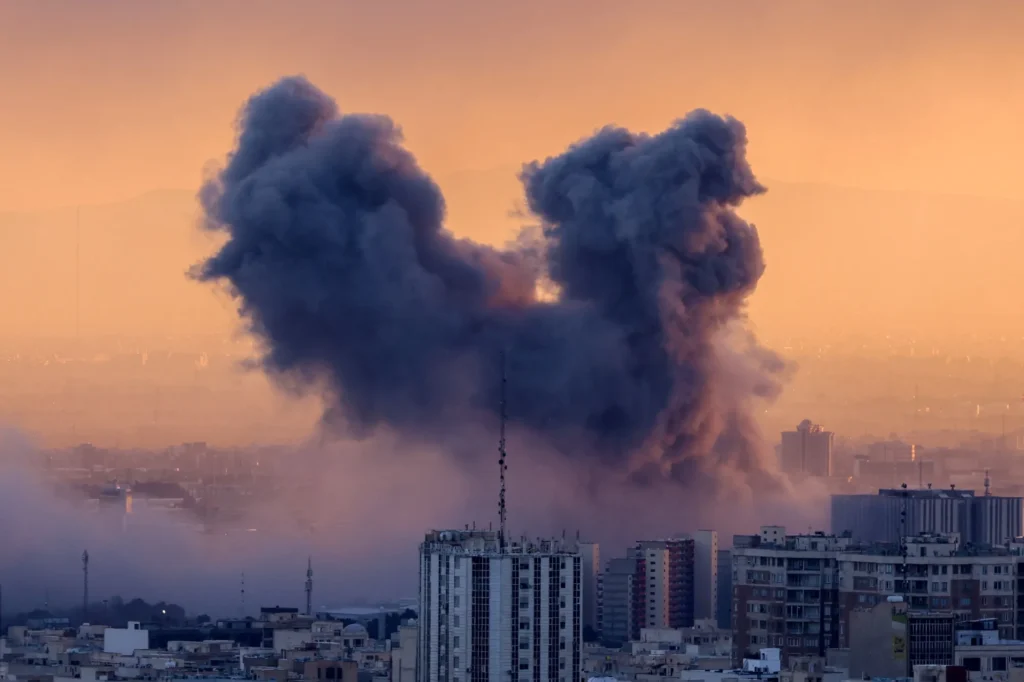 IRAN ATTACKS BY US-ISRAEL - A plume of smoke rises after a strike on the Iranian capital Tehran, on March 3.Photographer: Atta Kenare/AFP/Getty Images
