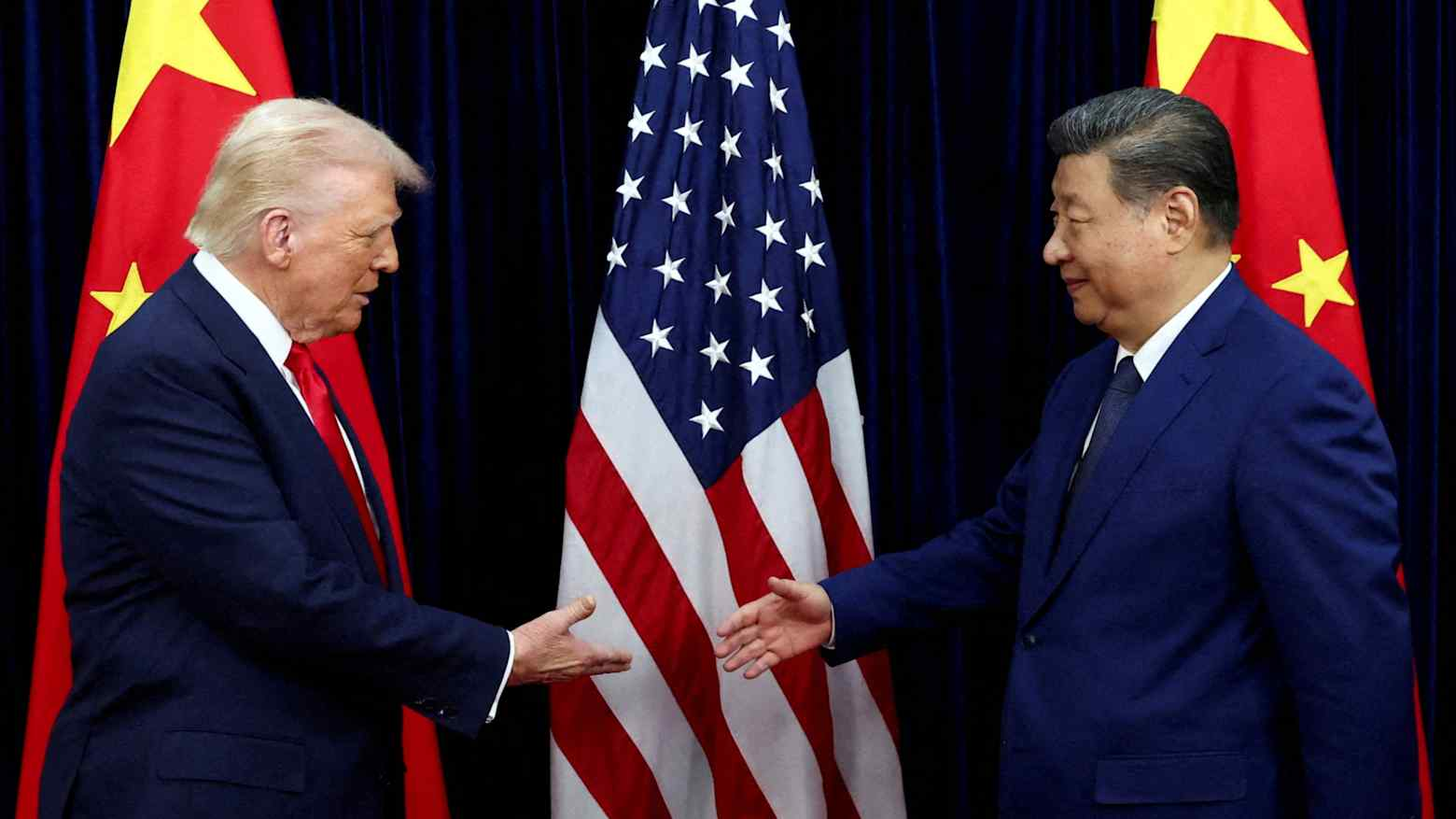 U.S. President Donald Trump shakes hands with Chinese President Xi Jinping at their last meeting in Busan, South Korea, on Oct. 30. They are set to meet again in Beijing this week. - image: Reuters