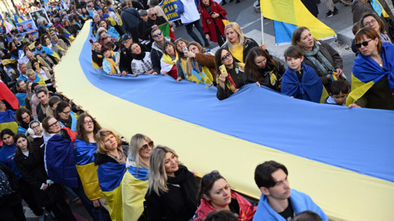 WESTERN MEDIA BLARING ABOUT 'VIBE SHIFT' IN UKRAINE - People hold a giant Ukrainian flag during a march for Ukraine ahead of the fourth anniversary of Russia's invasion, in Paris on 21 February 2026. AFP - BERTRAND GUAY
