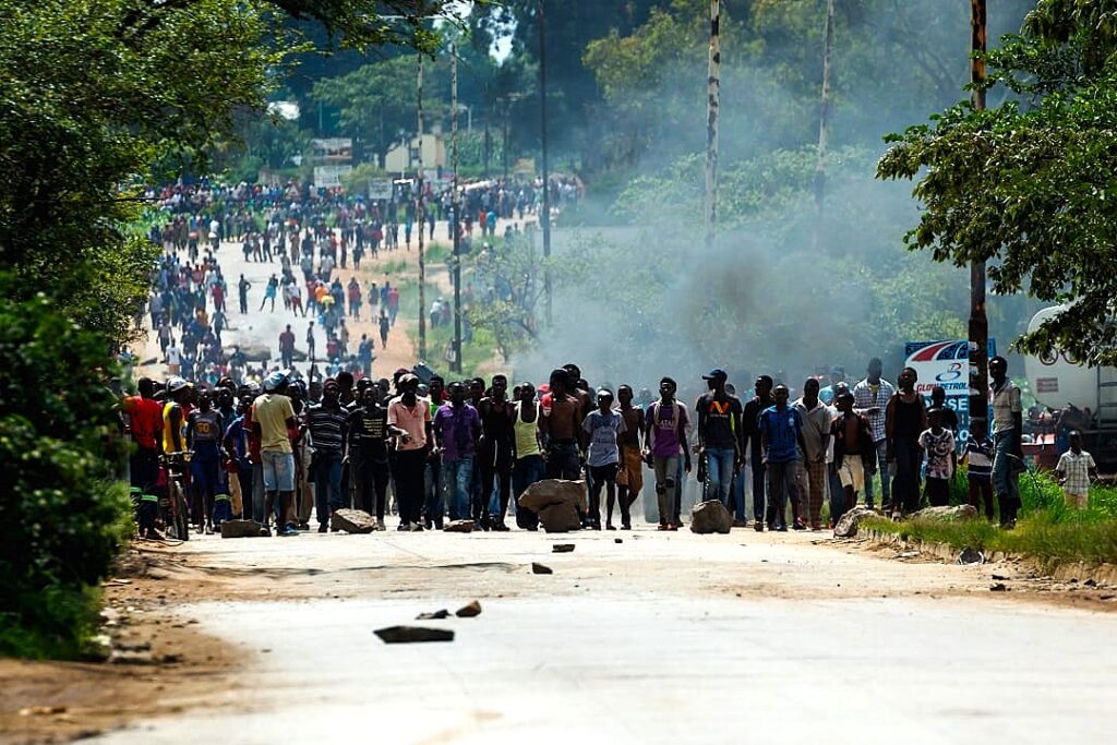 NATIONAL SHUTDOWN ZIMBABWE - IMAGE: INTERNATIONAL CRISIS GROUP - Angry protesters barricade the main route to Zimbabwe's capital Harare from Epworth township on January 14 2019 after announced a more than hundred percent hike in fuel prices. - Angry protesters barricaded roads with burning tyres and rocks in Zimbabwe on January 14 after the government more than doubled the price of fuel in a bid to improve supplies as the country battles its worst gasoline shortages in a decade. (Photo by Jekesai NJIKIZANA / AFP)